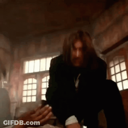 Man With Long Hair And Beard Sitting On Bed GIF