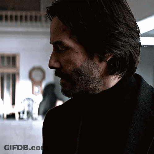 Man With Long Hair And Beard Standing In Dark Room GIF