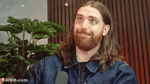 Man With Long Hair And Beard Talking Into Microphone GIF