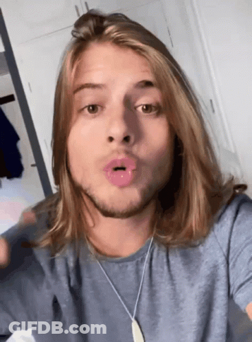Man With Long Hair And Beard Wearing Blue Shirt And Necklace GIF