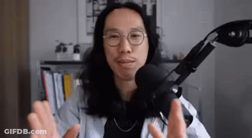 Man With Long Hair And Glasses Talking Into Microphone GIF