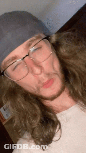 Man With Long Hair And Glasses Wearing Baseball Cap GIF
