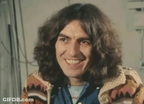 Man With Long Hair And Sweater Smiling At Camera GIF