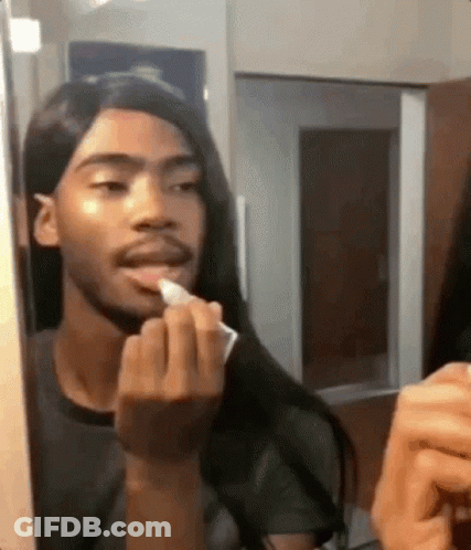 Man With Long Hair Applying Lipstick In Mirror GIF