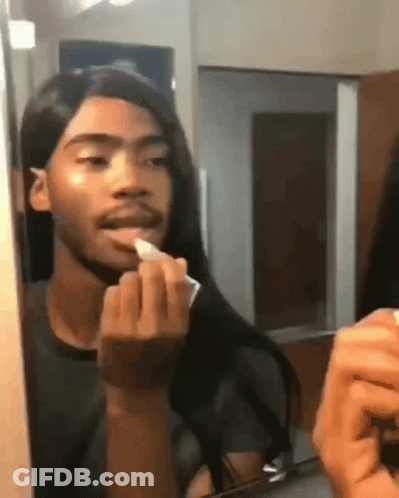 Man With Long Hair Applying Lipstick In Mirror GIF