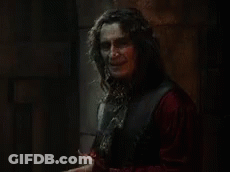 Man With Long Hair Holding Knife In Dark Room GIF