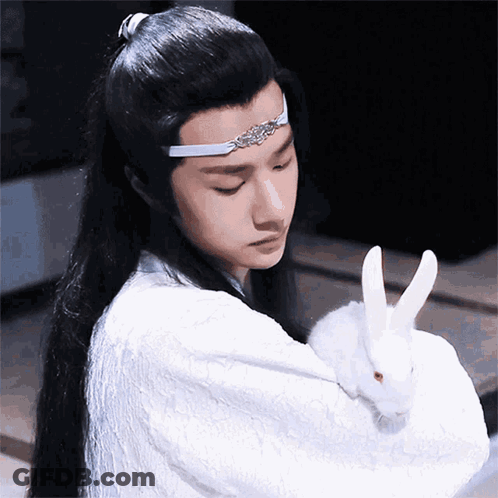 Man With Long Hair Holding White Rabbit GIF