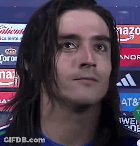 Man With Long Hair In Front Of Corona Ads GIF