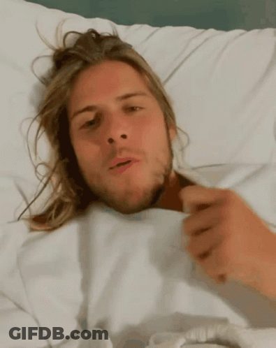 Man With Long Hair Laying In Bed GIF