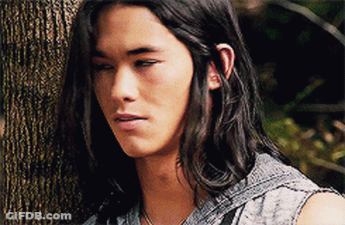 Man With Long Hair Leaning Against Tree GIF