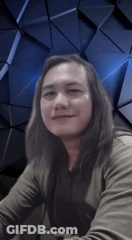 Man With Long Hair Looking At Camera Blue Background GIF