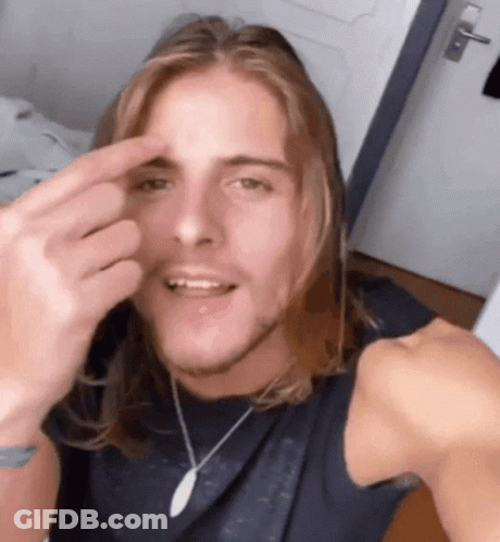 Man With Long Hair Making Funny Face With Finger GIF