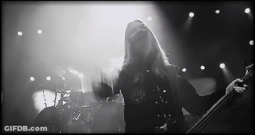 Man With Long Hair Playing Bass Guitar On Stage GIF