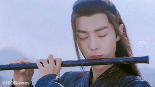 Man With Long Hair Playing Flute Blue Background GIF