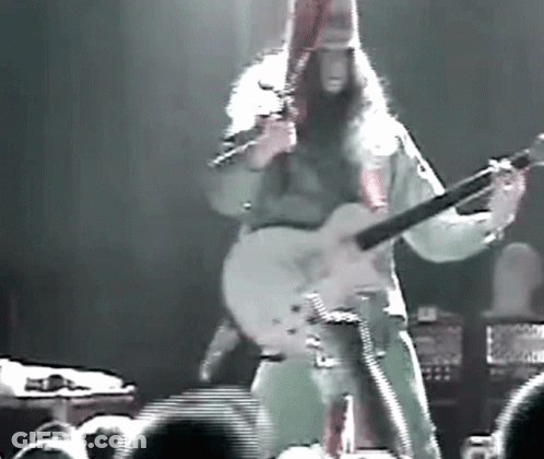 Man With Long Hair Playing Guitar On Stage GIF