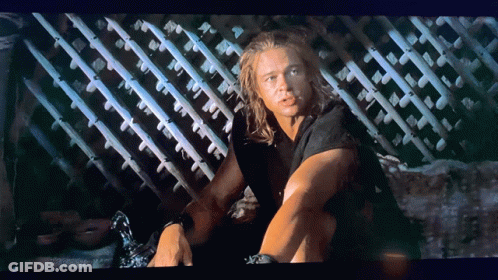 Man With Long Hair Sitting By Fence GIF