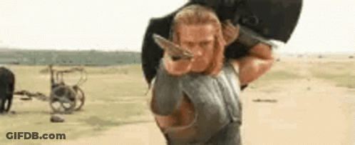 Man With Long Hair Sitting By Fence GIF