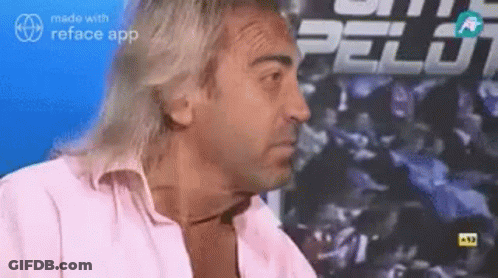Man With Long Hair Sitting In Front Of Pelot Sign GIF