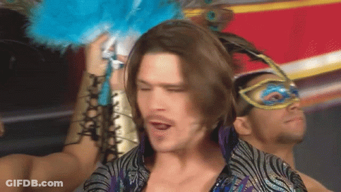Man With Long Hair Wearing Mask Holding Blue Feather GIF