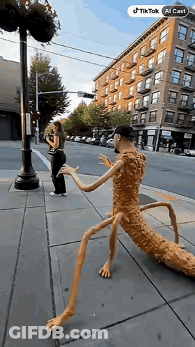 Man With Long Legs Standing Beside Woman Taking Picture GIF