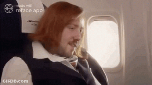 Man With Long Red Hair Sitting On Plane GIF