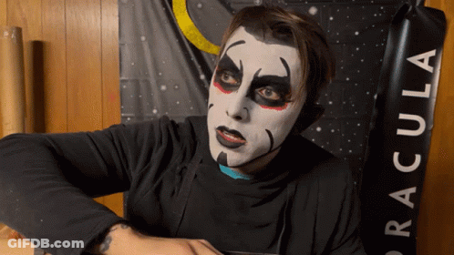 Man With Makeup In Front Of Dracula Banner GIF