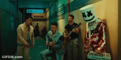 Man With Marshmallow Head Playing Guitar In Hallway GIF