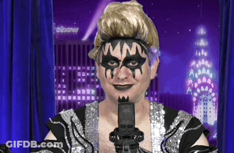 Man With Mask Holding Microphone In Front Of Febbane Building GIF