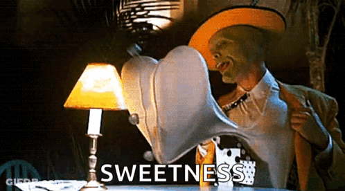 Man With Mask Sitting At Table With Lamp And Sweetness GIF