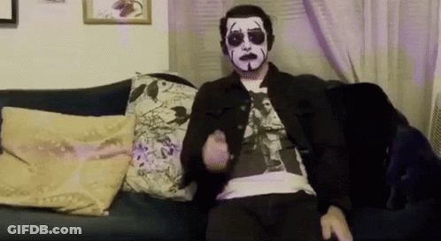 Man With Mask Sitting On Couch With Remote GIF