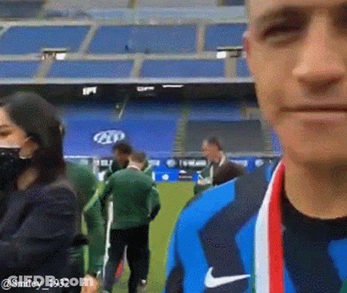 Man With Medal In Front Of Stadium GIF