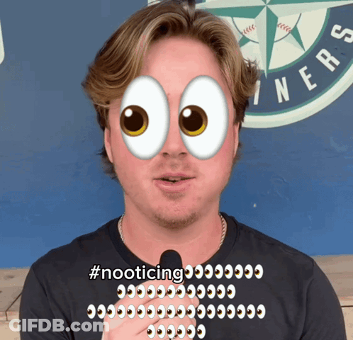 Man With Microphone In Front Of Seattle Mariners Logo With Cartoon Eye On Face GIF