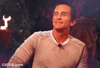 Man With Microphone Smiling In Front Of Fire Torch GIF