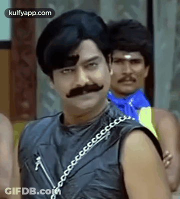 Man With Mustache And Chain Around Neck Standing Next To Another Man GIF
