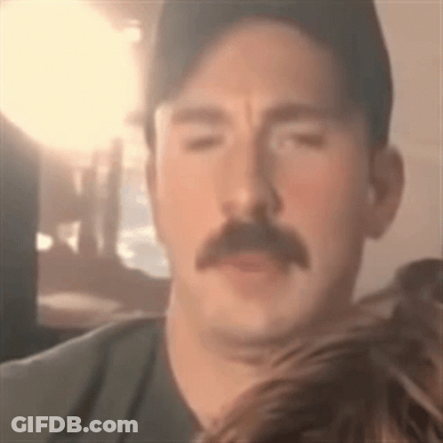 Man With Mustache And Hat Looking At Camera GIF