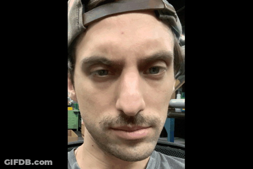 Man With Mustache And Hat Looking At Camera GIF