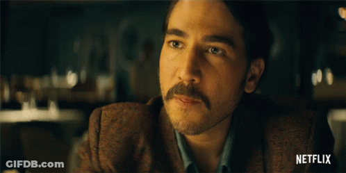 Man With Mustache At Table With Netflix Logo GIF