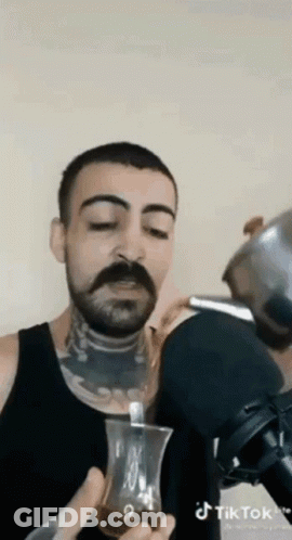 Man With Mustache Drinking From Glass With Spoon GIF