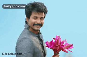 Man With Mustache Holding Pink Flowers Smiling GIF