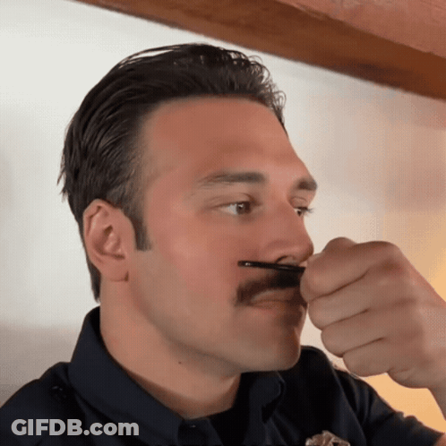 Man With Mustache Holding Something In Mouth GIF