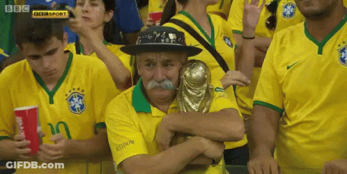 Man With Mustache Holding Trophy In Yellow Shirt Crowd GIF