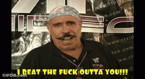 Man With Mustache In Front Of Sign Saying I Beat The Fuck Outta You GIF