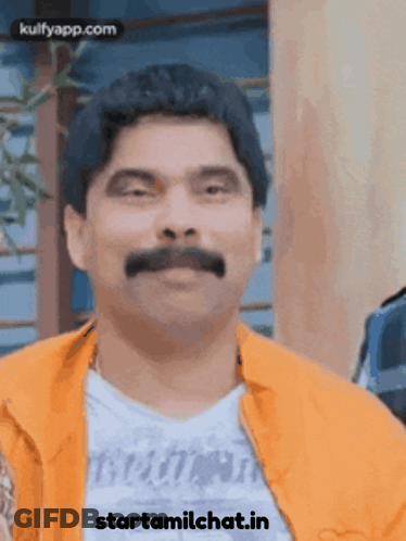 Man With Mustache In Orange Jacket Saying Starttamilchat.in GIF