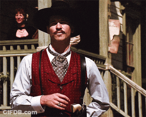 Man With Mustache In Red Vest And Suspenders Holding Gun GIF