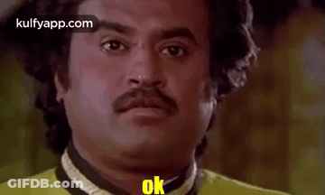 Man With Mustache In Yellow Shirt Making Funny Face Saying Ok GIF