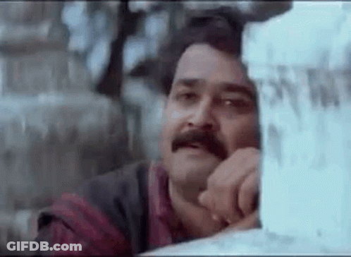 Man With Mustache Leaning Against Wall Gazing Out Window GIF