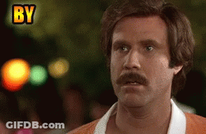 Man With Mustache Making Funny Face In Front Of By Sign GIF
