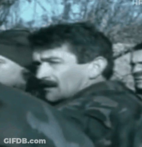 Man With Mustache Next To Group Of Men Black And White GIF