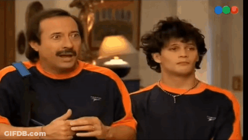 Man With Mustache Next To Man In Orange And Black Shirt GIF