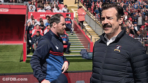 Man With Mustache On Soccer Field With Another Man GIF